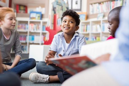 kinderen met boek in bibliotheek